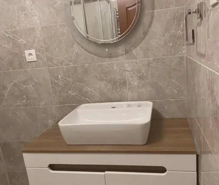 Ahşap tezgahlı beyaz banyo dolabı, tezgah üstü çanak lavabo ve yuvarlak LED ayna